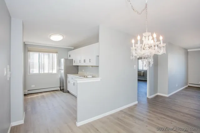 a room with chandelier and wooden floor