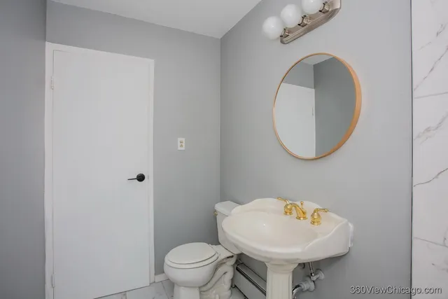 a bathroom with a toilet sink and mirror