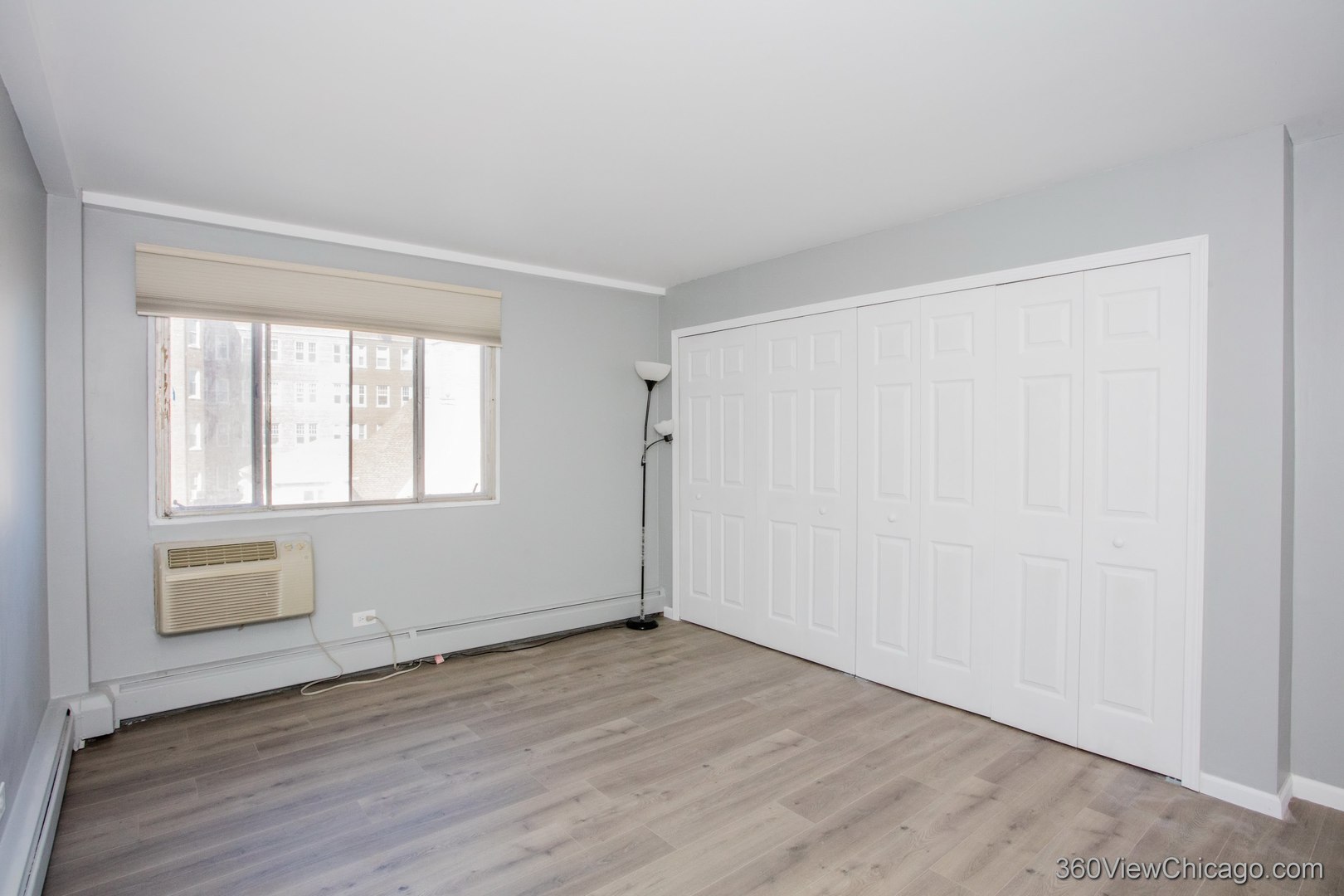 6300 North Sheridan Road, Unit 517 Chicago, IL 60660 - Photo 6 of 13 an empty room with wooden floor and windows