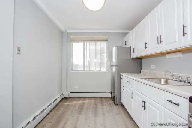 a kitchen with granite countertop white cabinets and white appliances