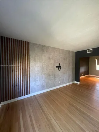a view of a big room with wooden floor and a ceiling fan
