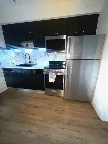 a view of kitchen with stainless steel appliances a refrigerator and a sink