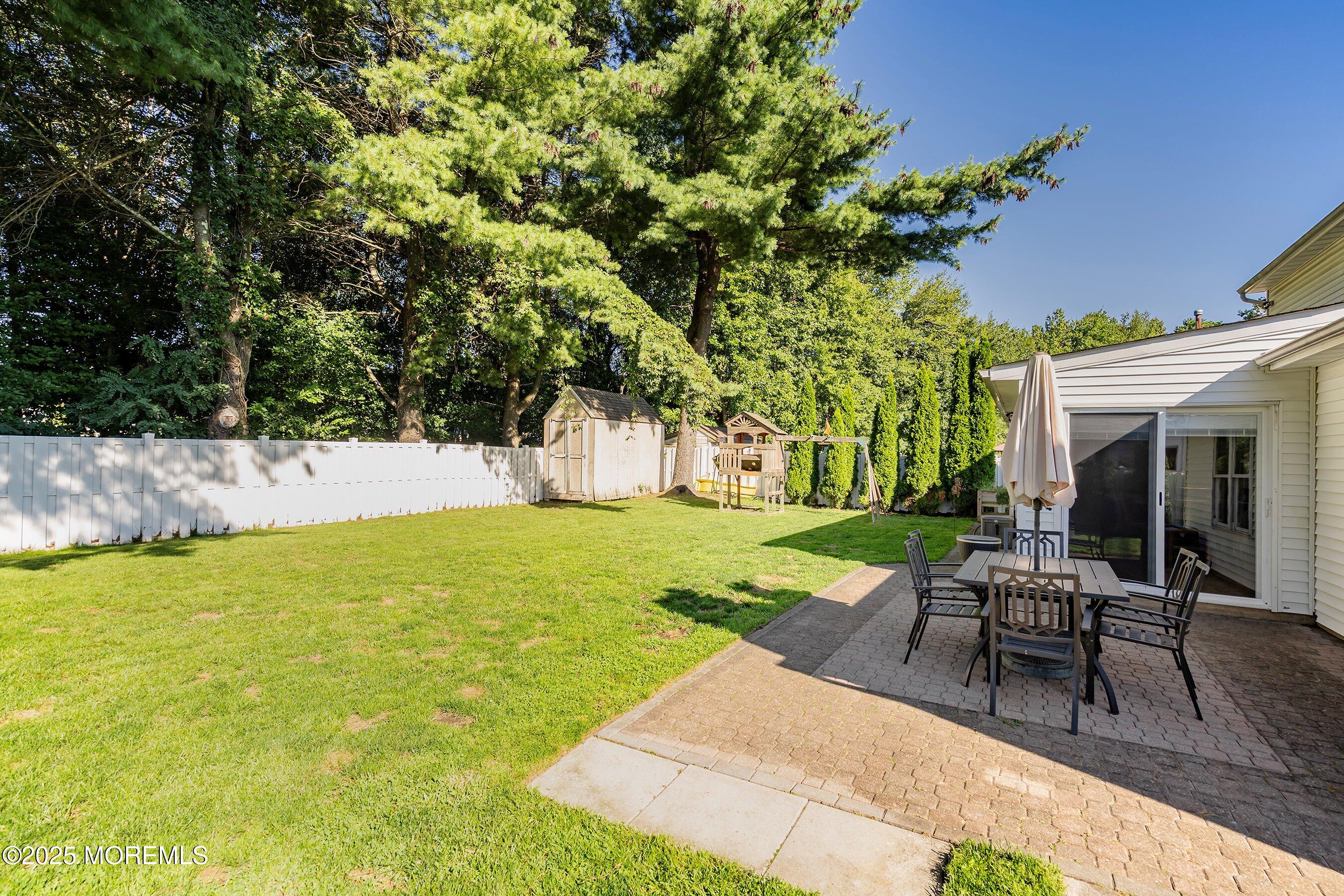 131 Starlight Road Howell, NJ 07731 - Photo 24 of 35 a view of a swimming pool with lawn chairs under an umbrella