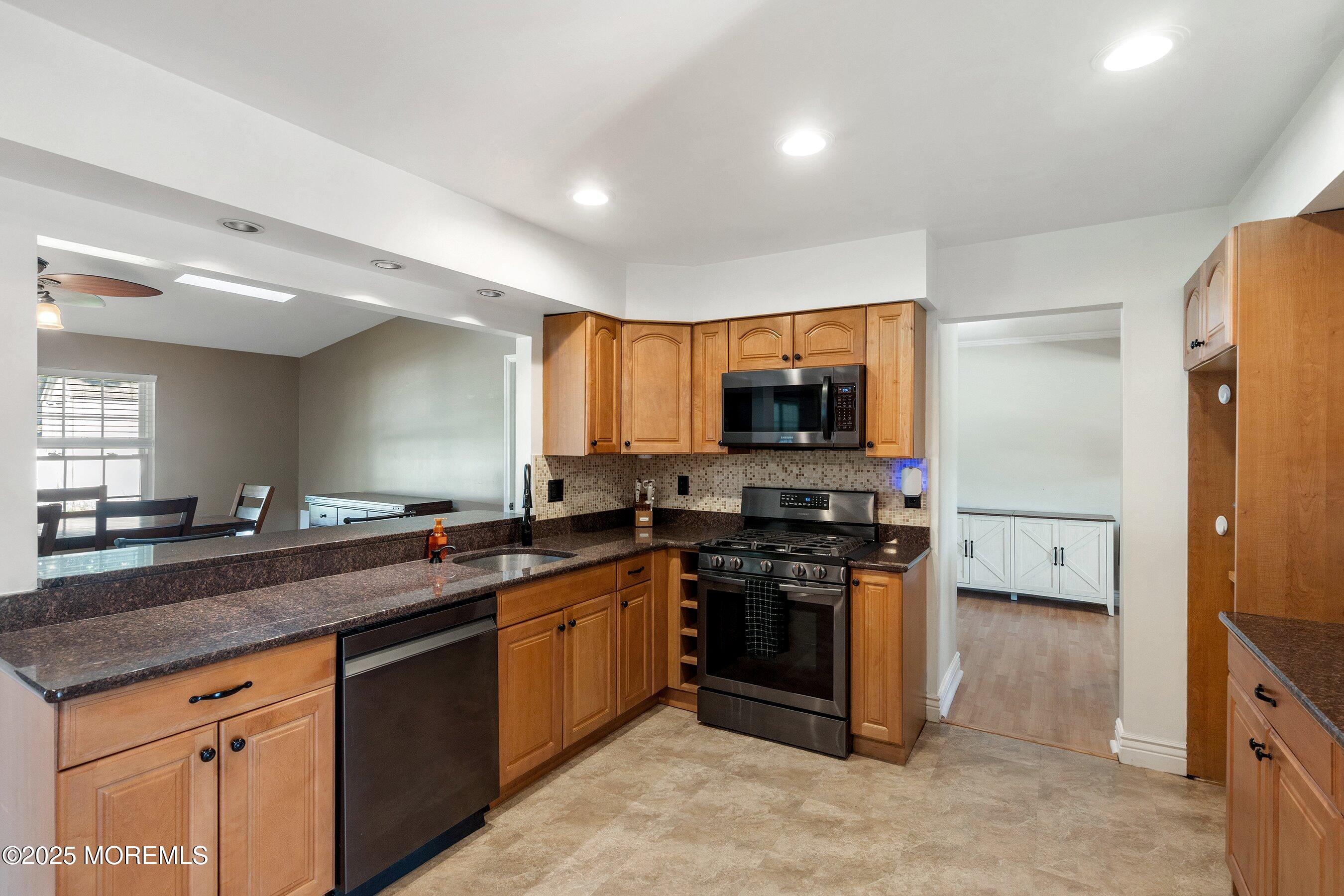 131 Starlight Road Howell, NJ 07731 - Photo 10 of 35 a kitchen with stainless steel appliances granite countertop a stove a sink and a refrigerator