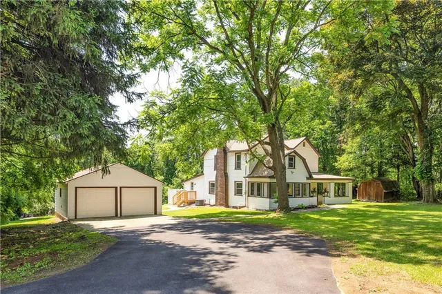 a front view of a house with a yard and trees