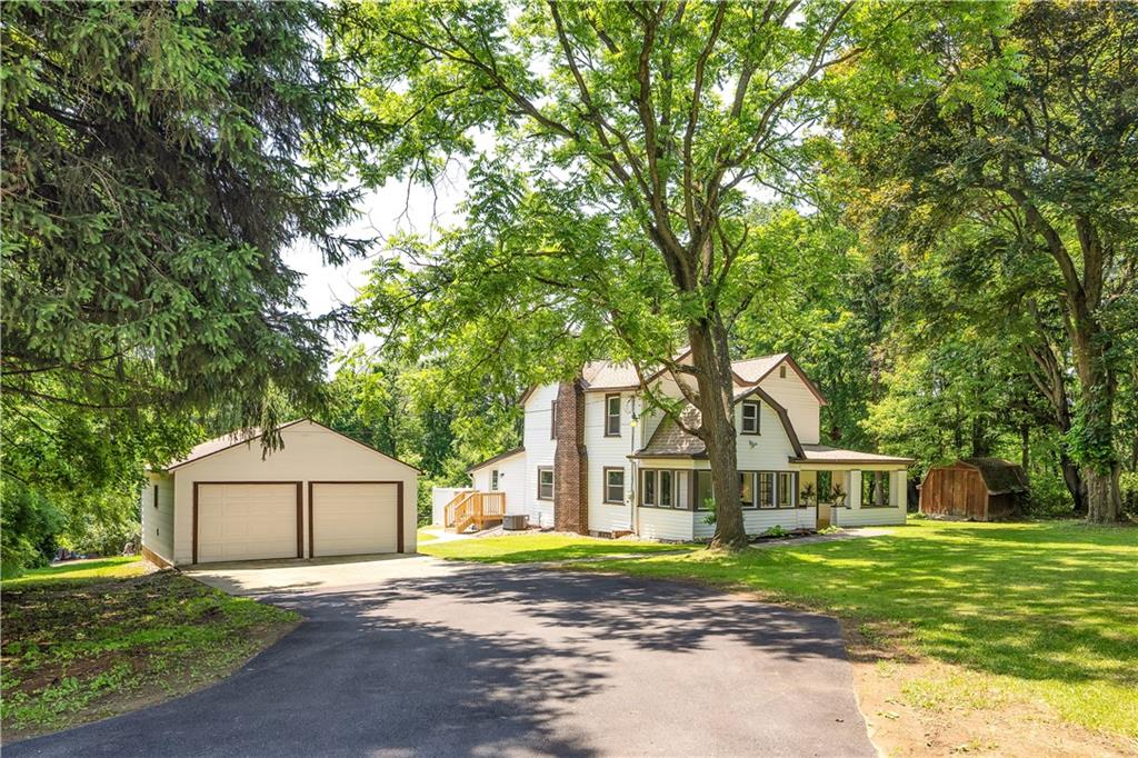 a front view of a house with a yard and trees