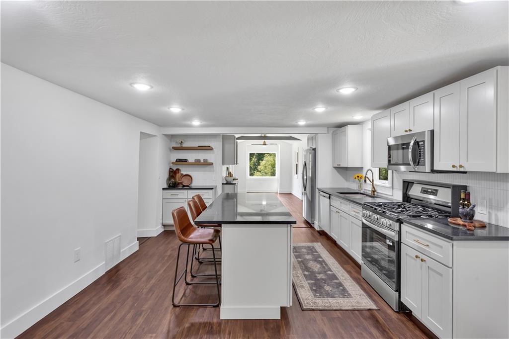 2165 Tuscarawas Road Beaver, PA 15009 - Photo 14 of 39 a view of a kitchen with kitchen island granite countertop wooden floors and stainless steel appliances