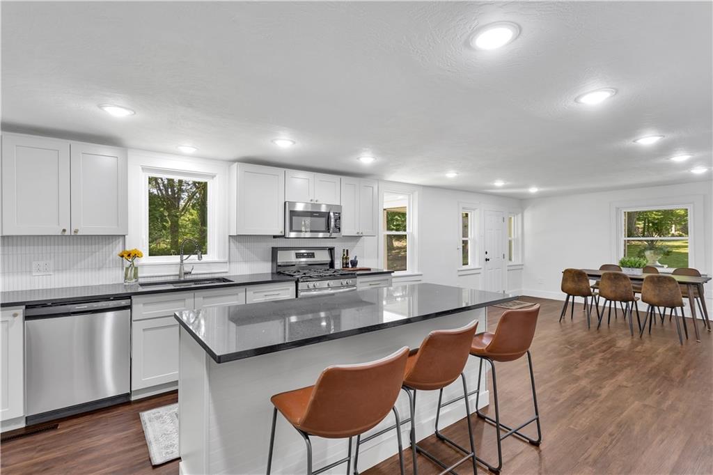 2165 Tuscarawas Road Beaver, PA 15009 - Photo 17 of 39 a kitchen with stainless steel appliances granite countertop a stove a sink a refrigerator a dining table and chairs