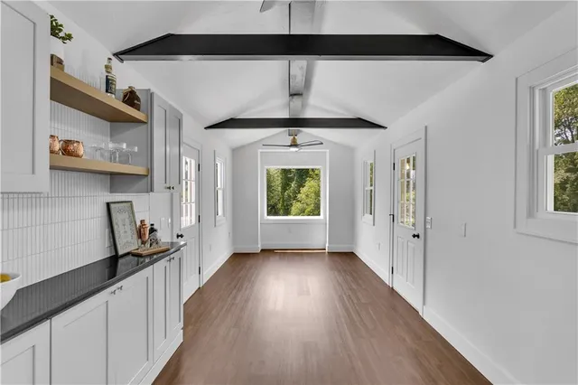 a view of a hallway with wooden floor and a living room