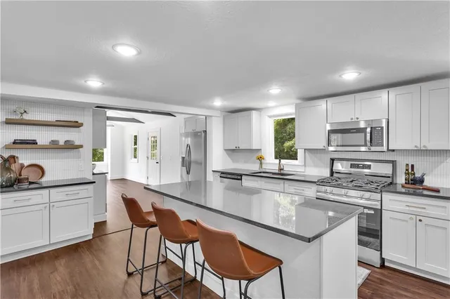 a kitchen with kitchen island granite countertop a sink and cabinets