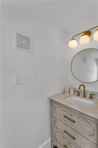 a bathroom with a sink vanity and a mirror