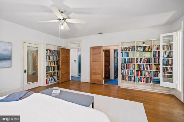 a living room with stainless steel furniture hardwood floor and a ceiling fan