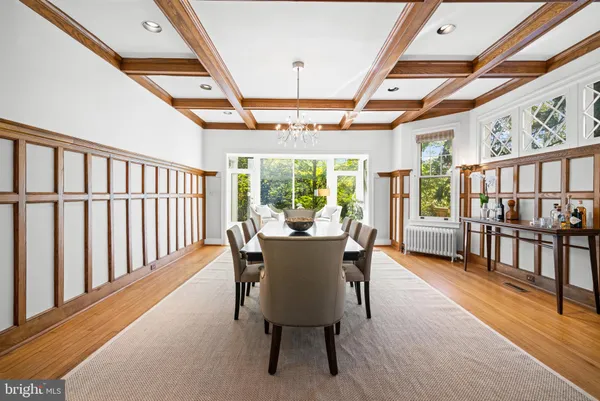 a dining room with furniture a chandelier and wooden floor