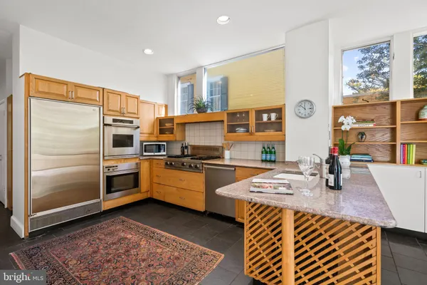 a kitchen with stainless steel appliances granite countertop a refrigerator sink and stove