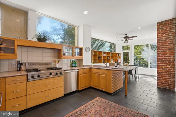 a kitchen with stainless steel appliances granite countertop a stove a sink and a dining table