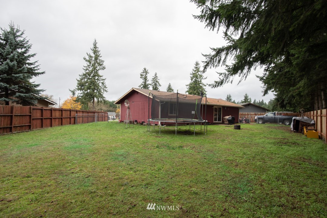 4620 Crescent Court Southwest Rochester, WA 98579 - Photo 2 of 12 a view of a backyard with potted plants and large trees