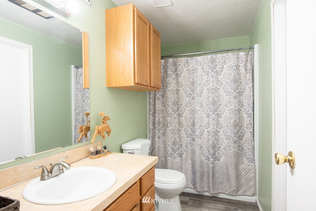4620 Crescent Court Southwest Rochester, WA 98579 - Photo 4 of 12 a bathroom with a granite countertop sink toilet and mirror