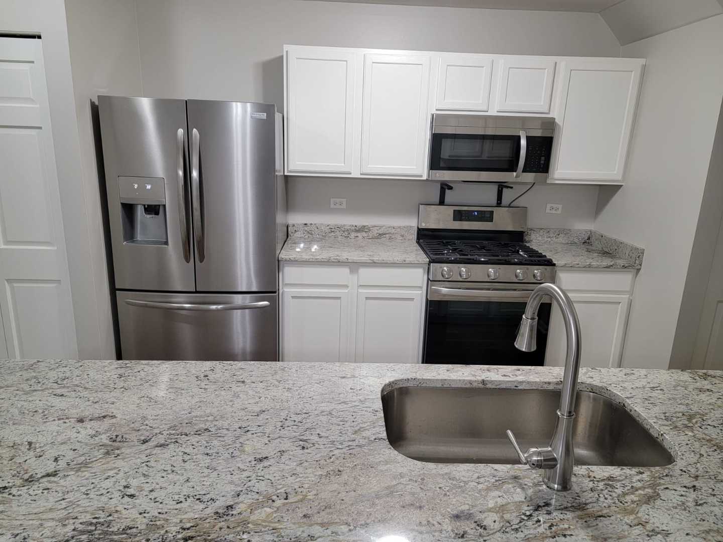 889 Symphony Drive Aurora, IL 60504 - Photo 11 of 24 a kitchen with stainless steel appliances granite countertop a stove a refrigerator and a sink