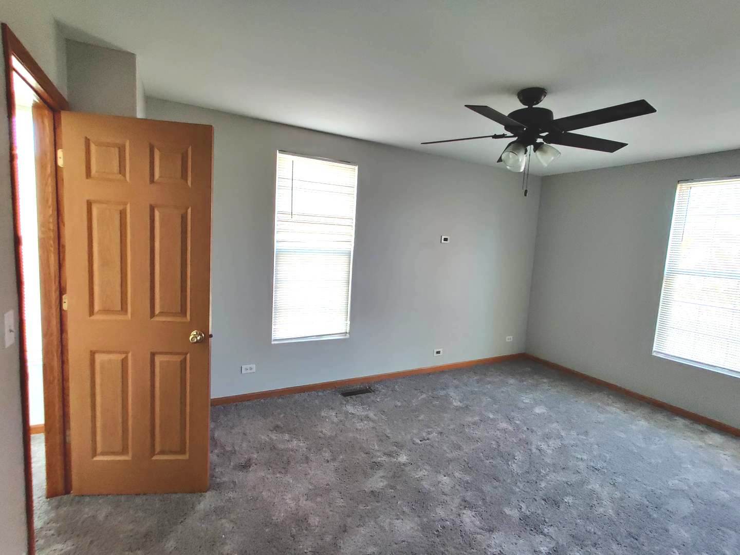 889 Symphony Drive Aurora, IL 60504 - Photo 17 of 24 an empty room with windows and fan