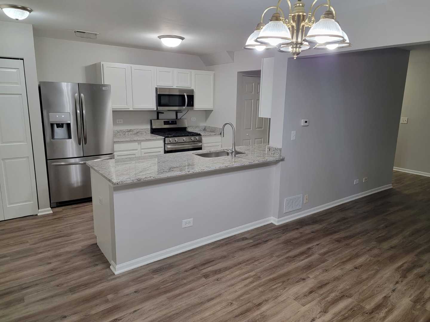 889 Symphony Drive Aurora, IL 60504 - Photo 8 of 24 a kitchen with stainless steel appliances granite countertop a refrigerator oven a sink dishwasher and white cabinets with wooden floor