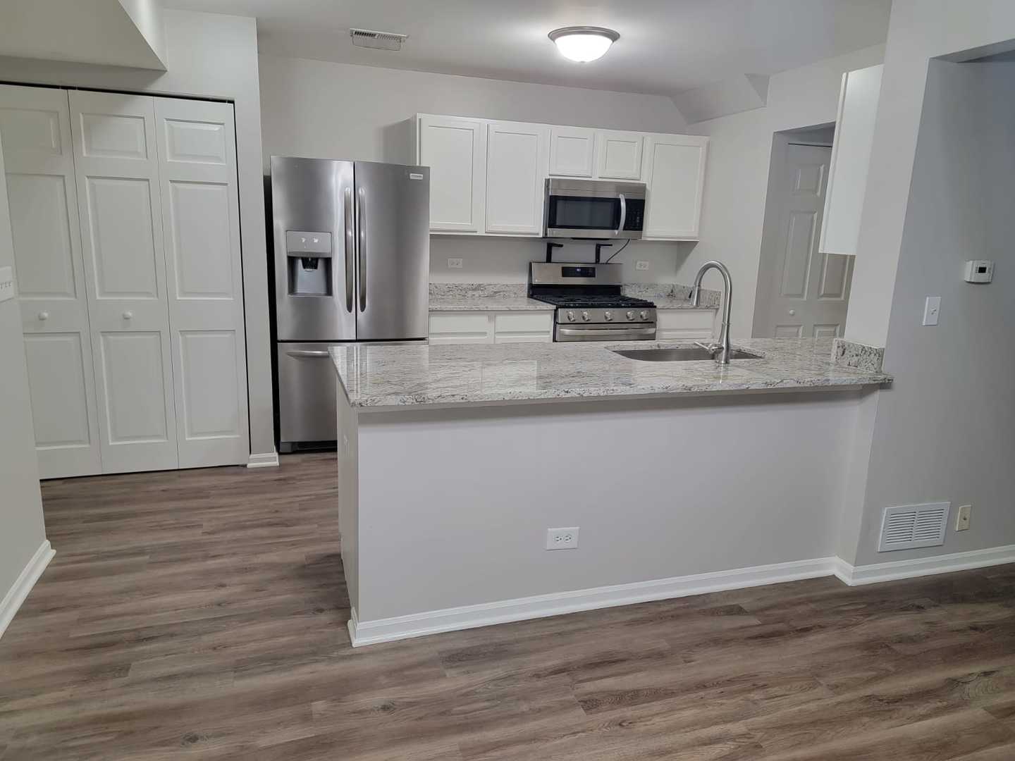 889 Symphony Drive Aurora, IL 60504 - Photo 10 of 24 a kitchen with kitchen island granite countertop a sink cabinets and stainless steel appliances