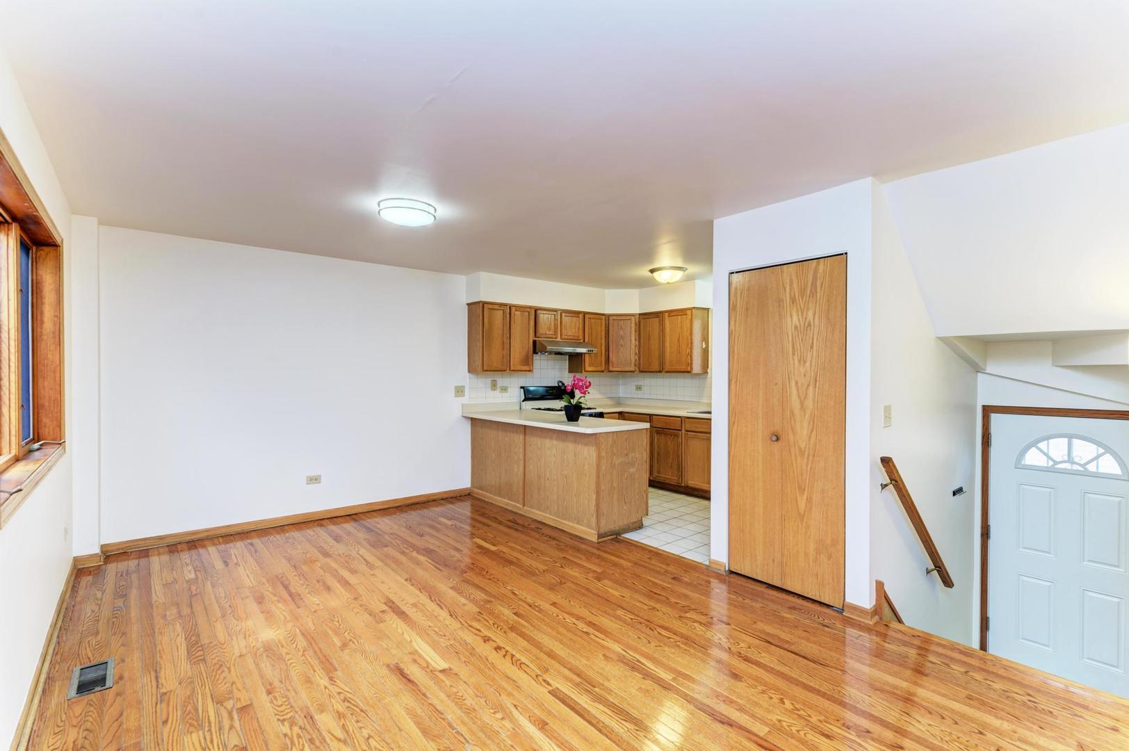 1333 West 32nd Street, Unit B Chicago, IL 60608 - Photo 8 of 29 a kitchen with stainless steel appliances kitchen island wooden floors and white counter top