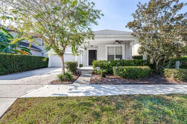 a front view of a house with a yard and potted plants