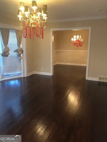 a view of a livingroom with wooden floor and a chandelier