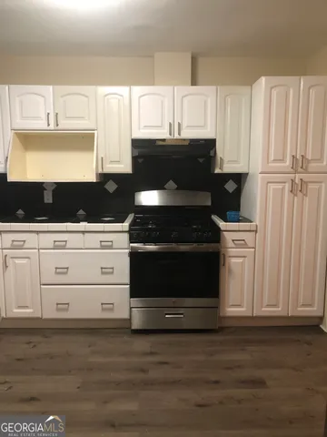 a kitchen with white cabinets and black appliances