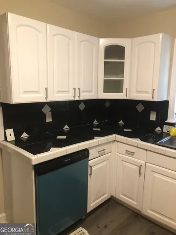 a kitchen with granite countertop white cabinets and sink