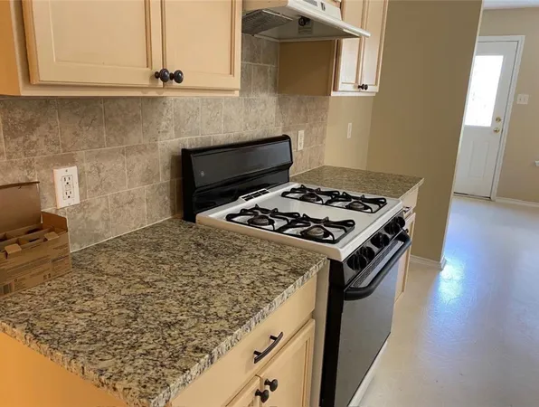 a white stove top oven sitting inside of a kitchen