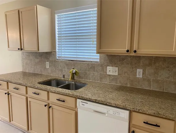 a kitchen with granite countertop white cabinets and a sink