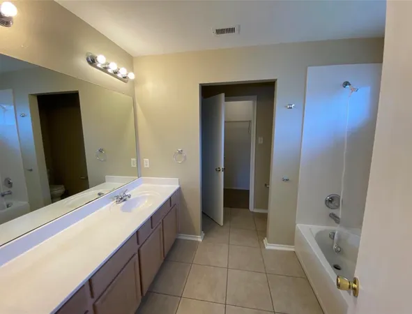 a spacious bathroom with a bathtub sink and mirror