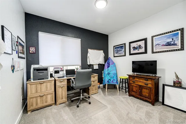 a view of a livingroom with workspace and a flat screen tv