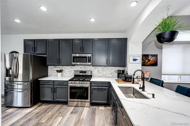 a kitchen with a sink stainless steel appliances and cabinets