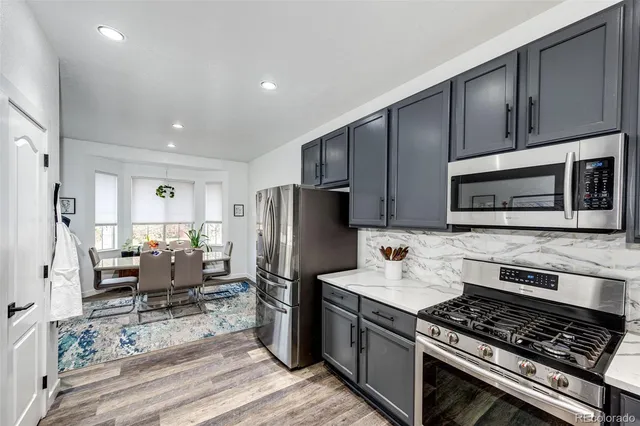 a kitchen with stainless steel appliances granite countertop a refrigerator stove microwave and sink