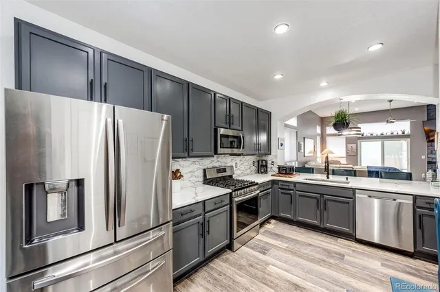 a kitchen with stainless steel appliances granite countertop a sink stove and refrigerator