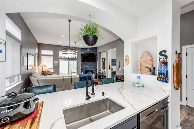 a kitchen with stainless steel appliances a sink a stove and a wooden floors