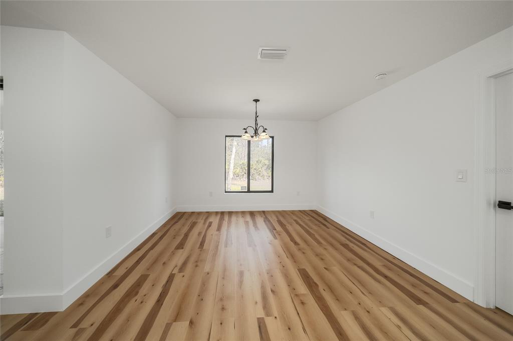 15460 Chamberlain Boulevard Port Charlotte, FL 33953 - Photo 18 of 24 a view of empty room with wooden floor and fan