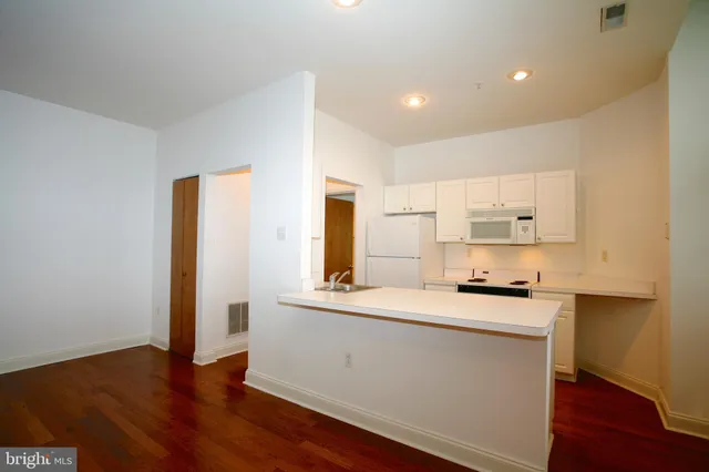 a kitchen with stainless steel appliances a sink a stove a refrigerator and cabinets