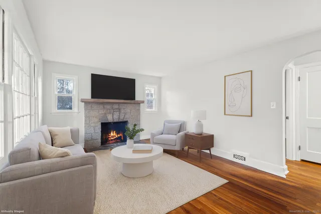 a living room with furniture a fireplace and a flat screen tv