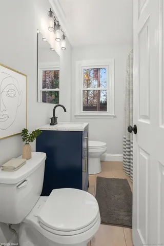 a bathroom with a toilet a sink and a mirror