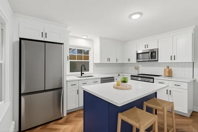 a kitchen with a refrigerator a stove a sink and white cabinets