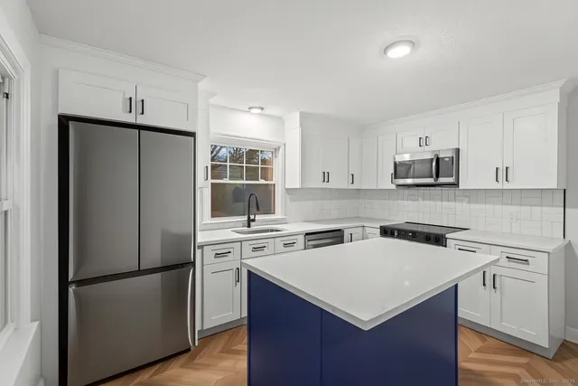 a kitchen with a stove a refrigerator and a sink