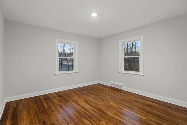 a view of a room with wooden floor and windows