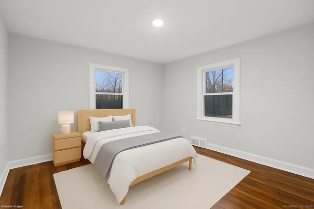 a bedroom with a bed and a painting on the wall