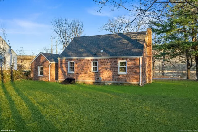 a front view of a house with a yard and trees