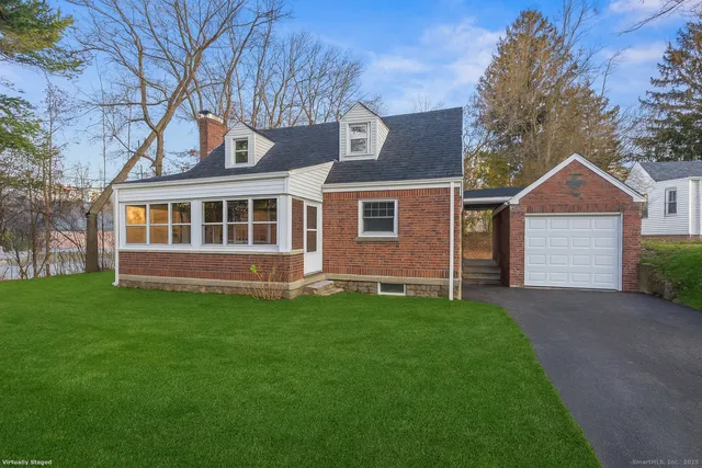 a view of a yard in front of a house with large windows