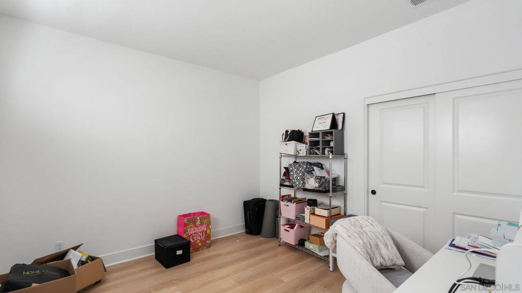 15681 Rennyson Way San Diego, CA 92127 - Photo 24 of 36 a bedroom with a bed and wooden floor