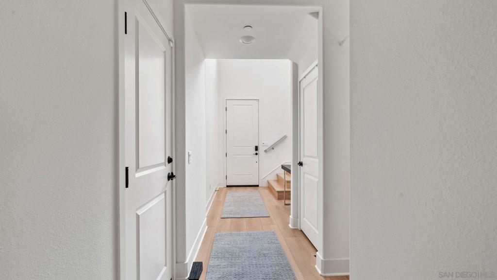 15681 Rennyson Way San Diego, CA 92127 - Photo 31 of 36 a view of a hallway with closet and a fireplace